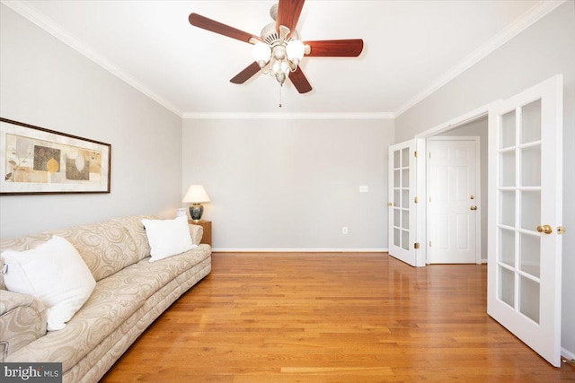 living area with light wood-style flooring, french doors, baseboards, and ornamental molding