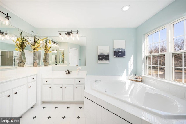 full bathroom with recessed lighting, a bath, and vanity