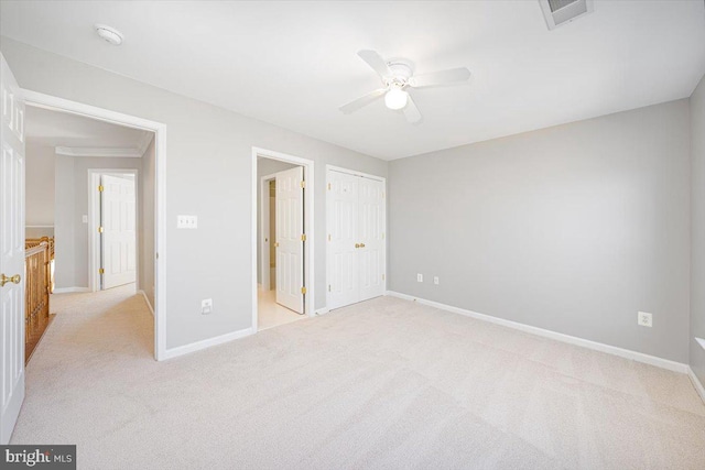 unfurnished bedroom with light colored carpet, baseboards, and visible vents