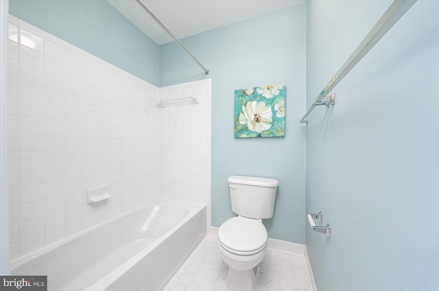 full bathroom with tile patterned flooring, toilet, washtub / shower combination, and baseboards