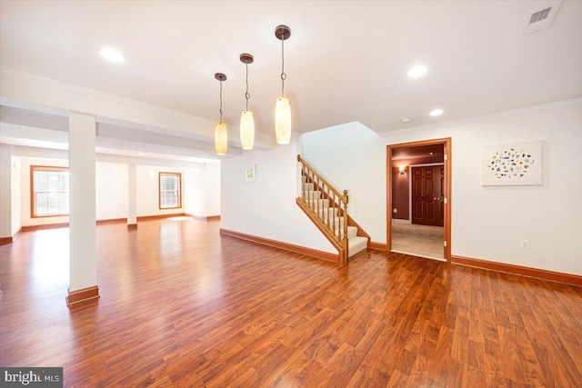 unfurnished living room with crown molding, stairs, baseboards, and wood finished floors