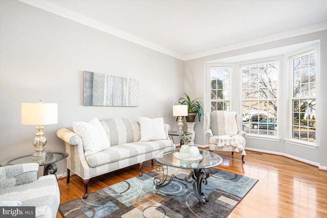 living area with baseboards, wood finished floors, and ornamental molding