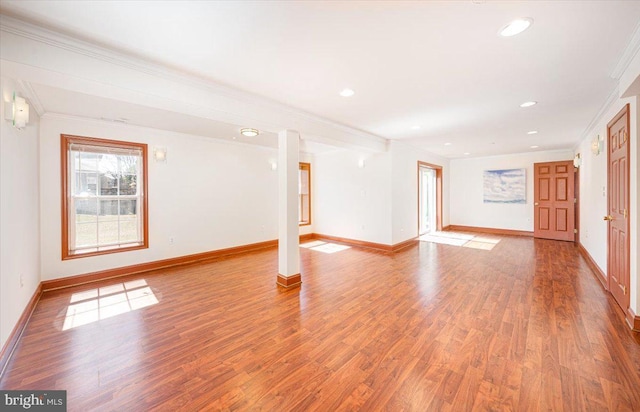 empty room with recessed lighting, baseboards, wood finished floors, and ornamental molding