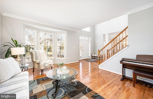 living room featuring crown molding, stairway, and wood finished floors