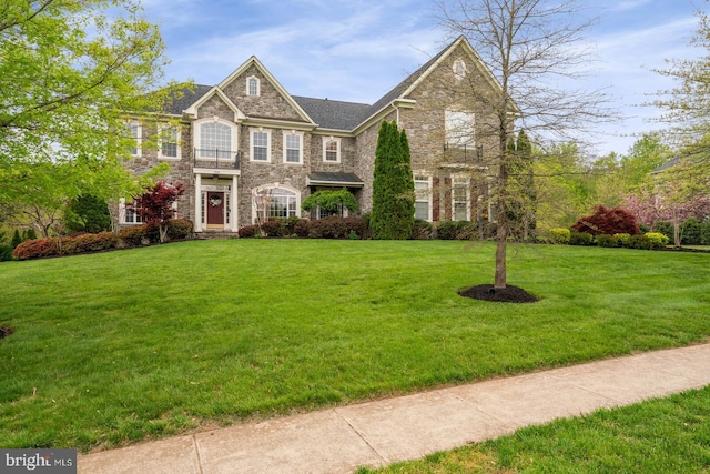 view of front of home with a front yard and stone siding