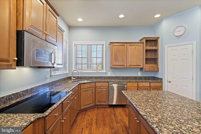 kitchen with a sink, brown cabinets, appliances with stainless steel finishes, dark wood-style floors, and open shelves