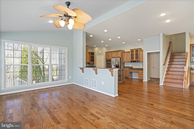 unfurnished living room with vaulted ceiling, recessed lighting, wood finished floors, and visible vents