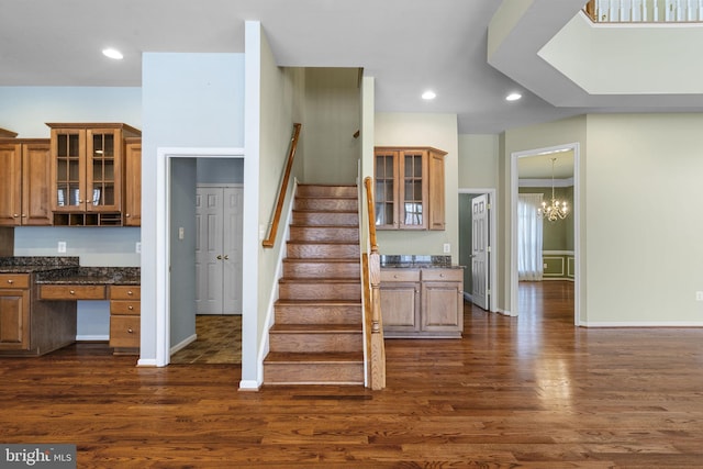 staircase featuring baseboards, a chandelier, recessed lighting, wood finished floors, and built in study area