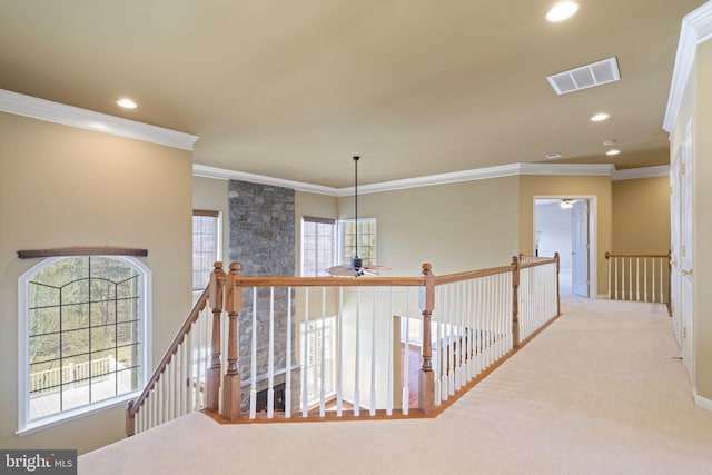 hallway featuring visible vents, recessed lighting, crown molding, carpet flooring, and an upstairs landing