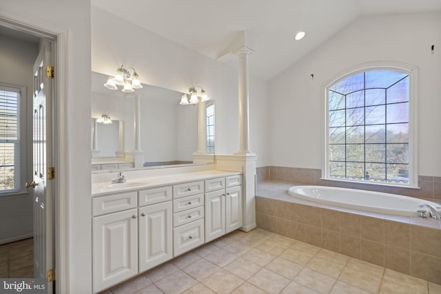 full bathroom featuring tile patterned flooring, lofted ceiling, a bath, vanity, and ornate columns