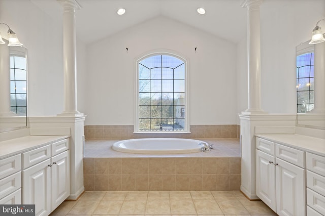 bathroom with tile patterned flooring, lofted ceiling, a garden tub, decorative columns, and vanity