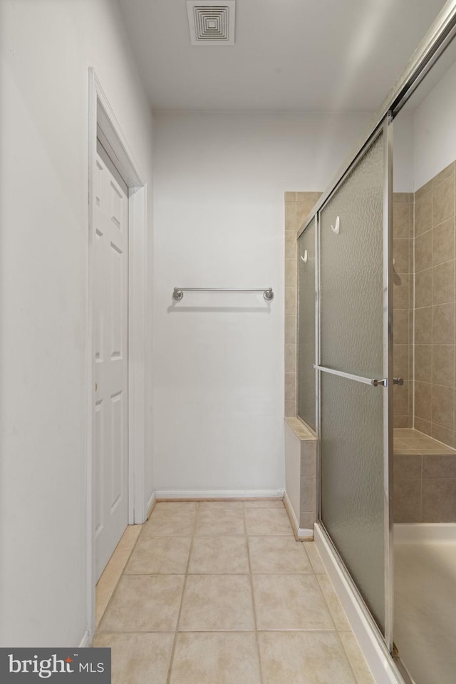 bathroom featuring tile patterned floors, visible vents, baseboards, and a stall shower