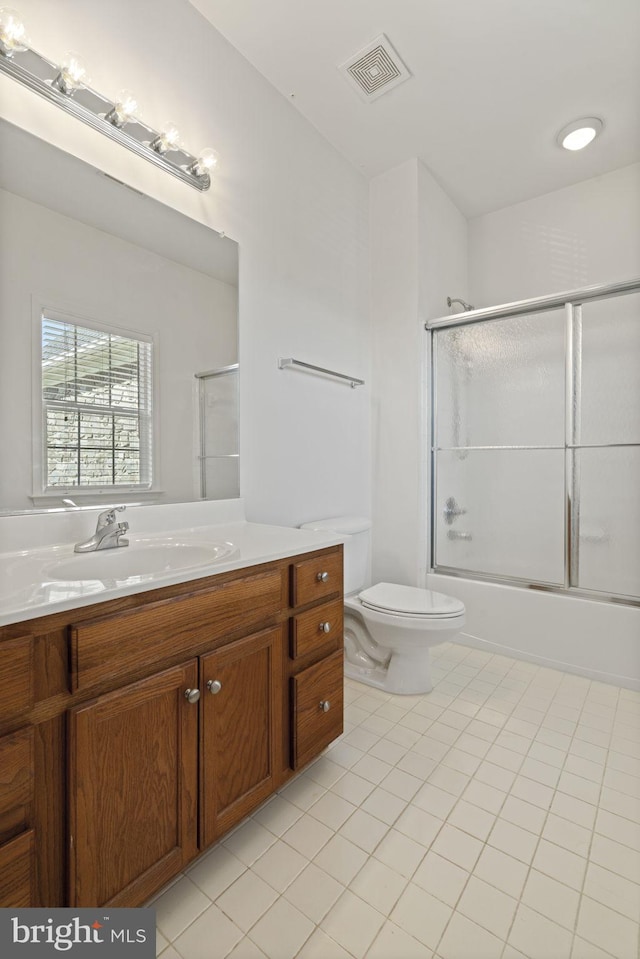 full bath with vanity, visible vents, shower / bath combination with glass door, tile patterned flooring, and toilet