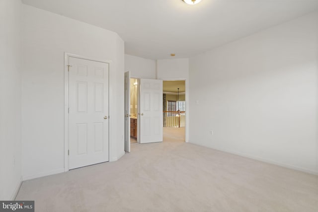 unfurnished bedroom with baseboards and light carpet