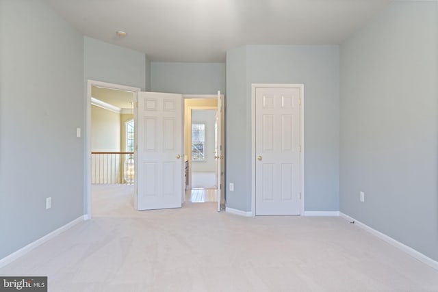 unfurnished bedroom with baseboards and light carpet