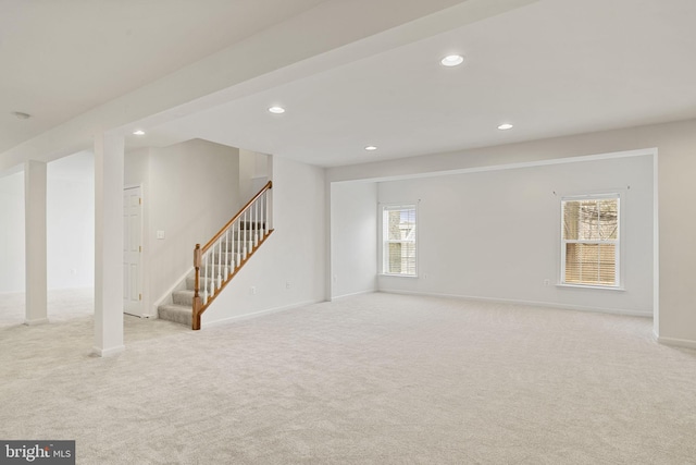 interior space featuring stairs, recessed lighting, baseboards, and light carpet