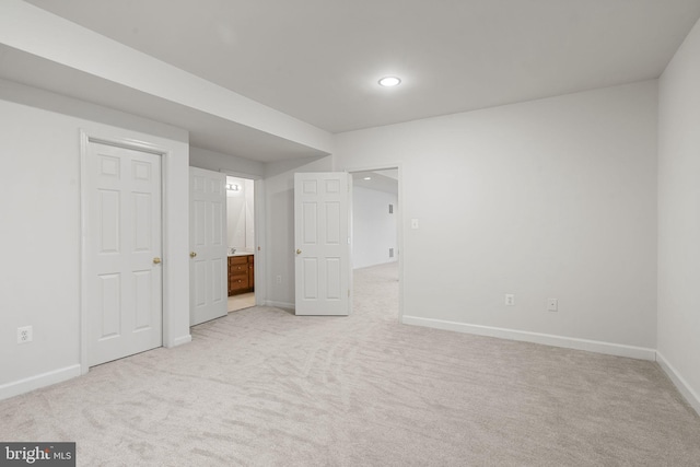 interior space featuring recessed lighting, baseboards, light carpet, and ensuite bath