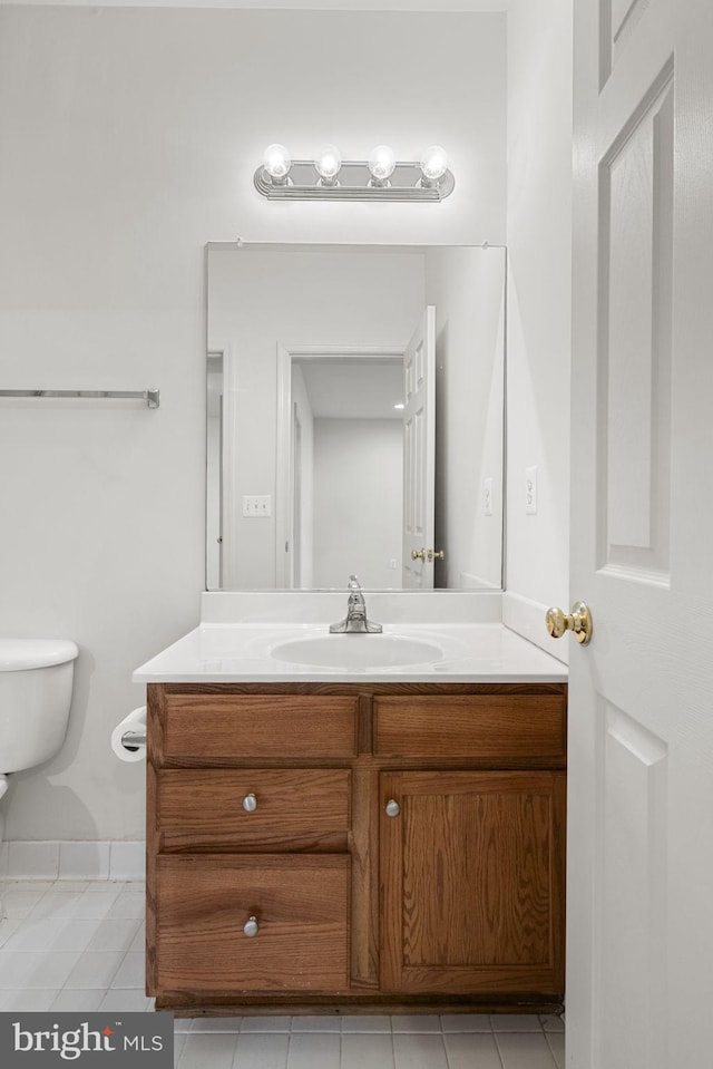 half bath with vanity, toilet, and tile patterned flooring