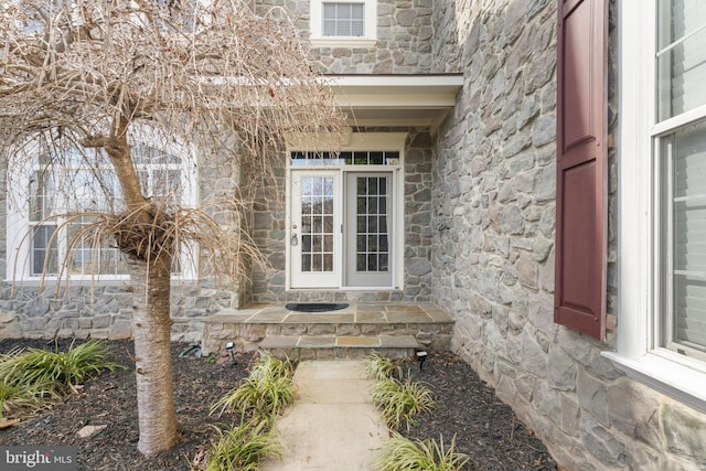 property entrance featuring visible vents and stone siding