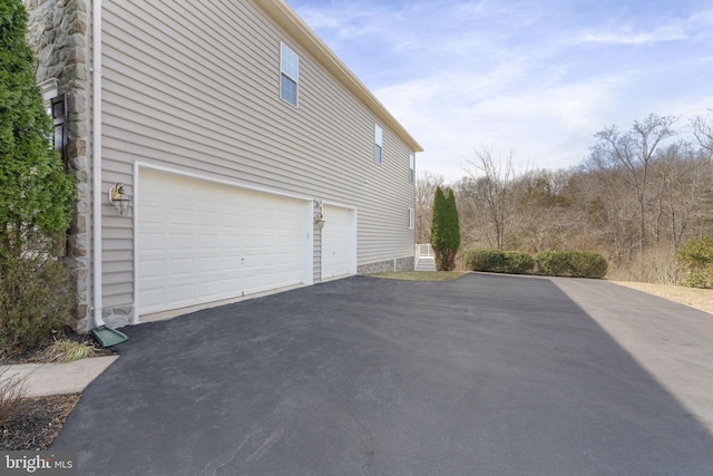 view of side of home with a garage and driveway