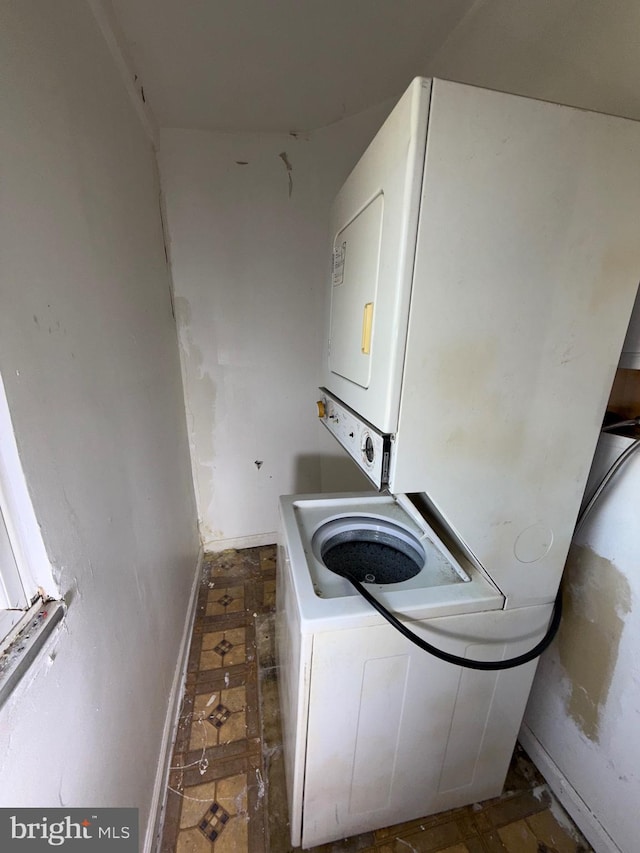 clothes washing area featuring laundry area and stacked washer and clothes dryer