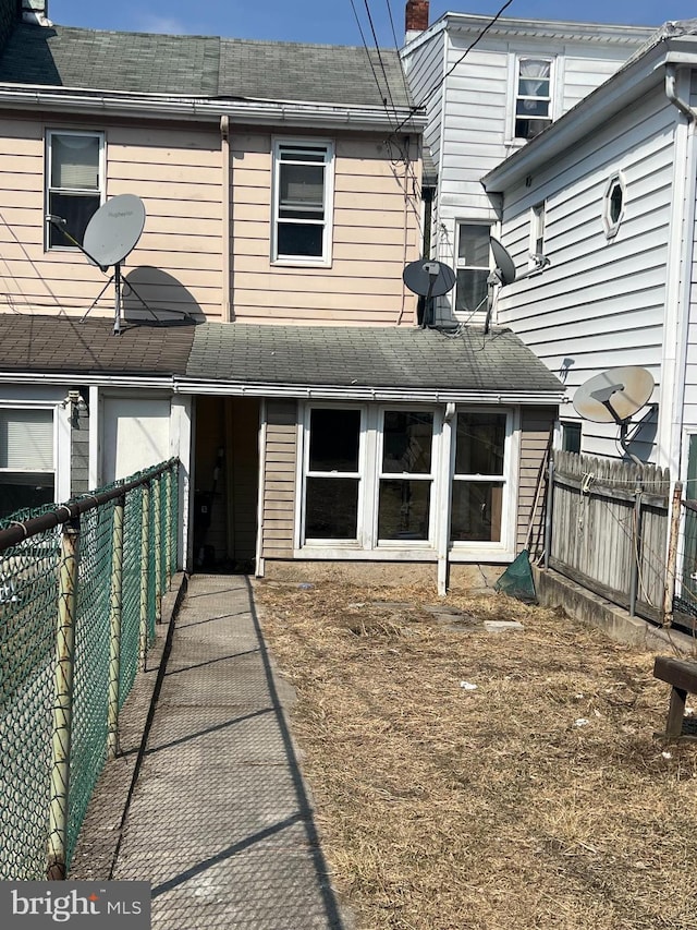 rear view of house with a fenced backyard