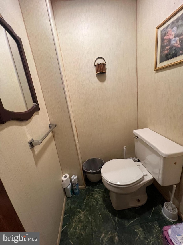 bathroom with toilet and marble finish floor