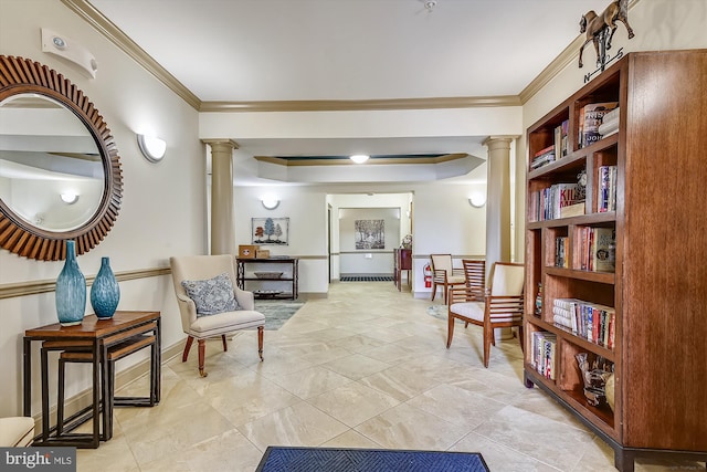 living area with baseboards, crown molding, and ornate columns