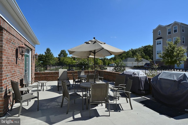 view of patio with fence, outdoor dining area, and area for grilling