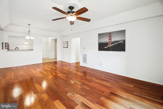 unfurnished living room featuring hardwood / wood-style flooring, visible vents, and a ceiling fan