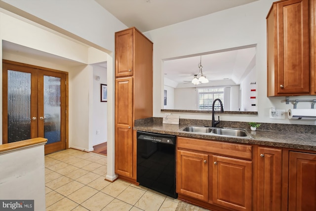 kitchen with dishwasher, brown cabinetry, dark countertops, and a sink