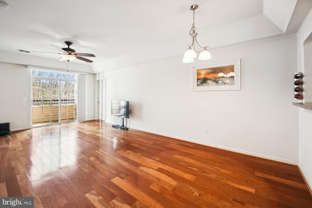 unfurnished living room featuring a ceiling fan, visible vents, baseboards, and wood finished floors