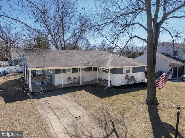 single story home featuring entry steps, concrete driveway, a front lawn, and roof with shingles