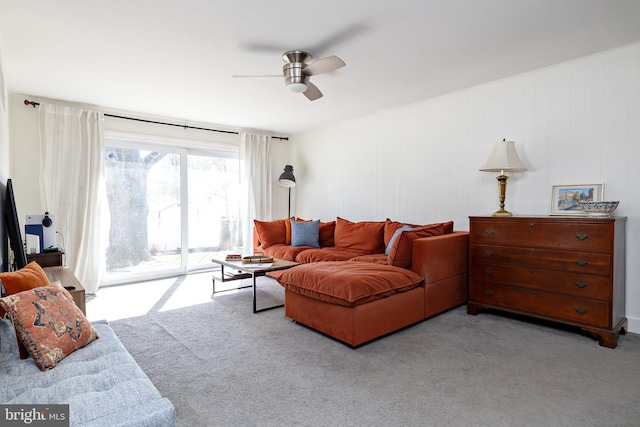 living area featuring carpet flooring and a ceiling fan