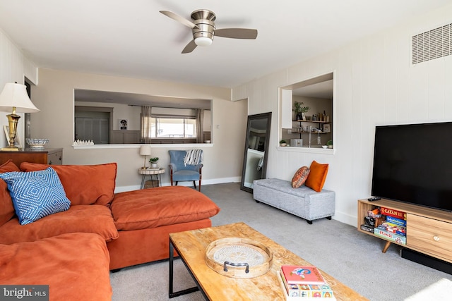 carpeted living area with visible vents, ceiling fan, and baseboards