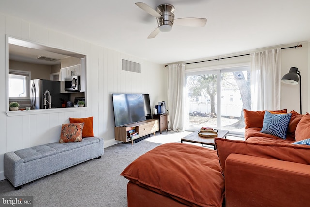 living area featuring carpet floors, plenty of natural light, and visible vents