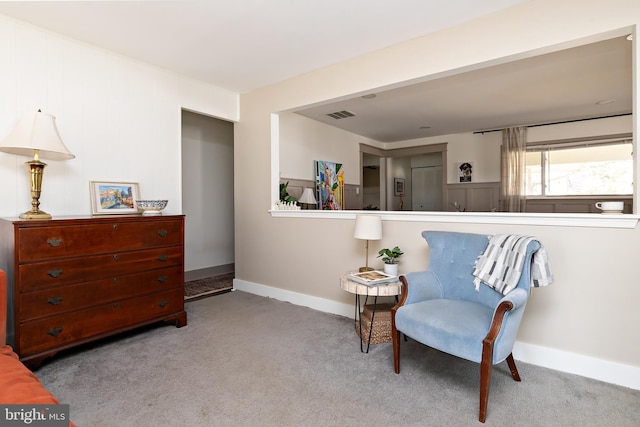 living area featuring carpet floors, visible vents, and baseboards