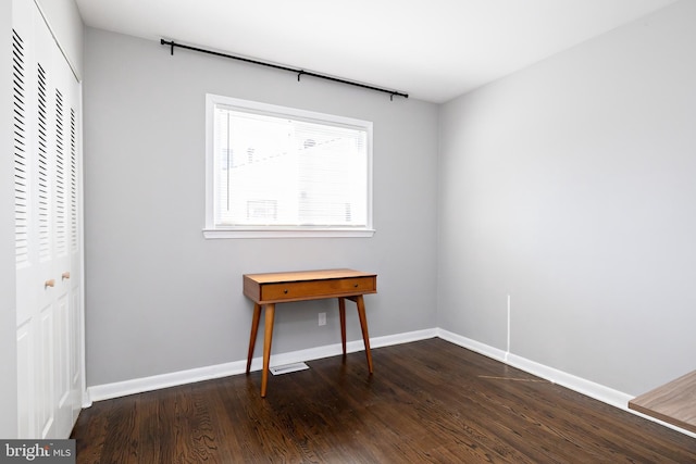 unfurnished bedroom featuring a closet, wood finished floors, and baseboards