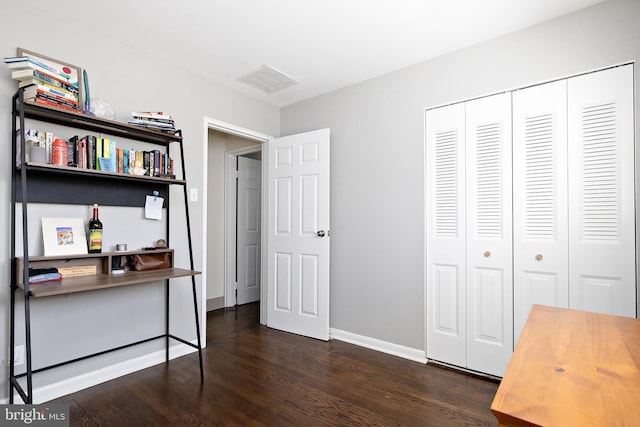 office space with dark wood-style flooring, visible vents, and baseboards