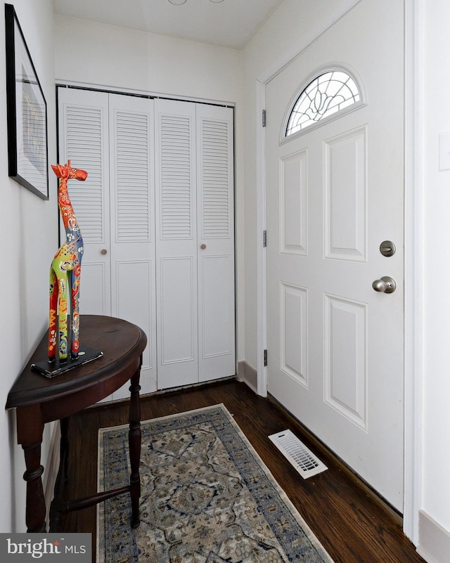 foyer entrance featuring dark wood-type flooring and visible vents