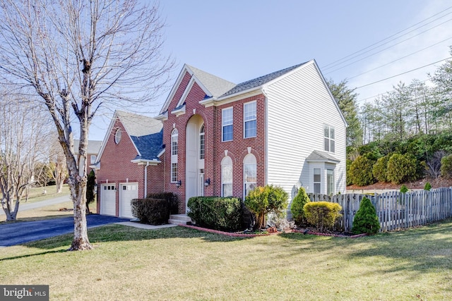 view of front of property featuring aphalt driveway, fence, an attached garage, a front yard, and brick siding