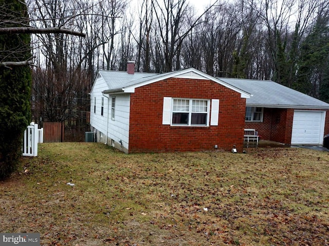 view of home's exterior with brick siding, central AC, a lawn, a chimney, and an attached garage