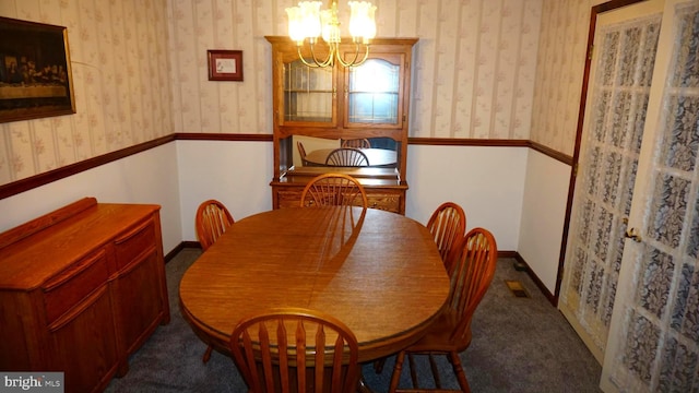 dining area featuring visible vents, a wainscoted wall, a chandelier, and wallpapered walls