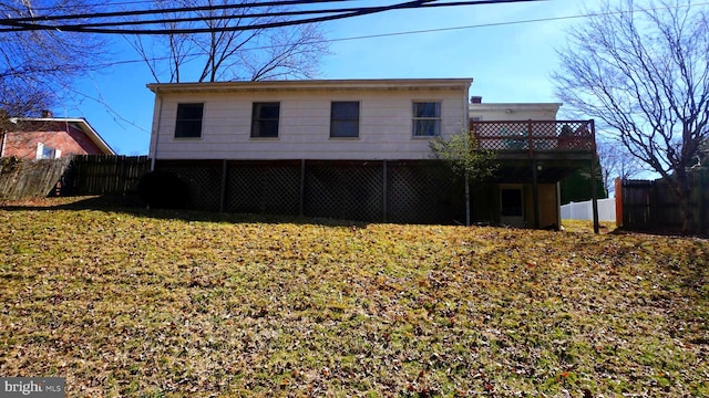 back of house featuring a lawn and fence