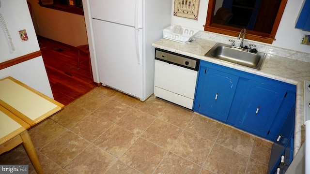 kitchen with light countertops, light tile patterned flooring, white appliances, blue cabinets, and a sink