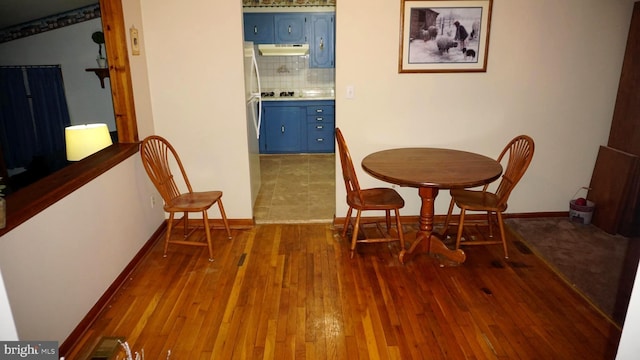 dining space with baseboards and wood-type flooring