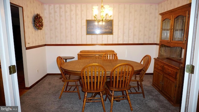 dining space with wallpapered walls, baseboards, a wainscoted wall, dark carpet, and an inviting chandelier