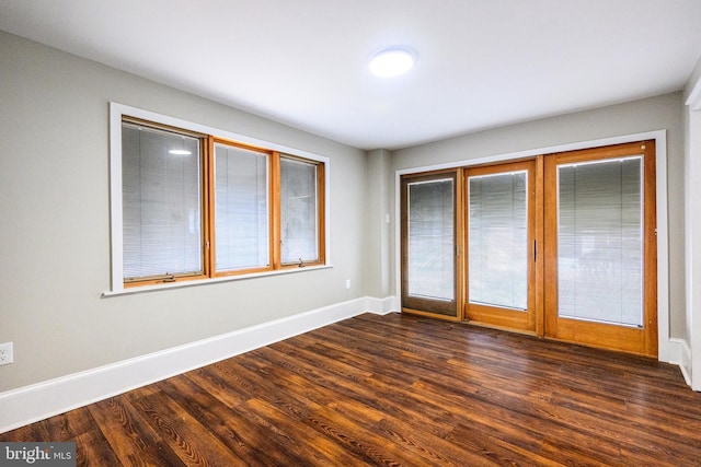 unfurnished bedroom with dark wood-style flooring and baseboards