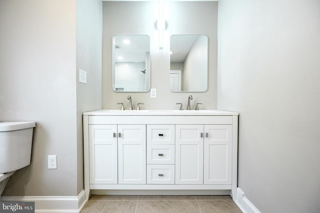 bathroom with tile patterned floors, a sink, baseboards, and double vanity