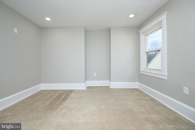 unfurnished room featuring recessed lighting, light carpet, and baseboards